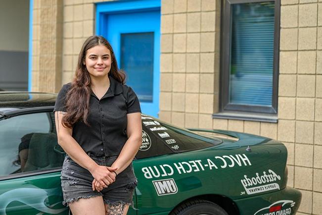 Leah C. leaning on car